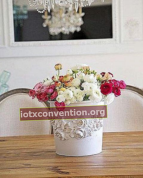 Un vaso bianco trasformato come decorazione in un vaso di fiori