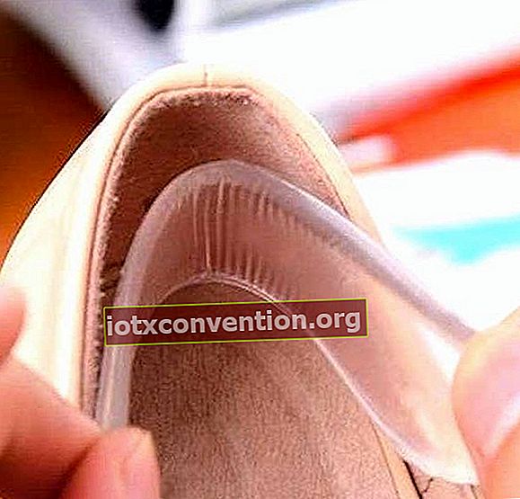 Tangan yang memasukkan pad silikon di dalam kasut.