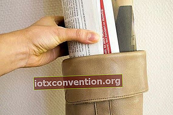 En hand som sätter in tidningen i skaftet på en läderkänga.