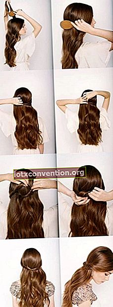 젊은 갈색 머리 여자는 뒷면에 그것을 매듭하여 그녀의 긴 머리를 묶는 방법을 보여줍니다