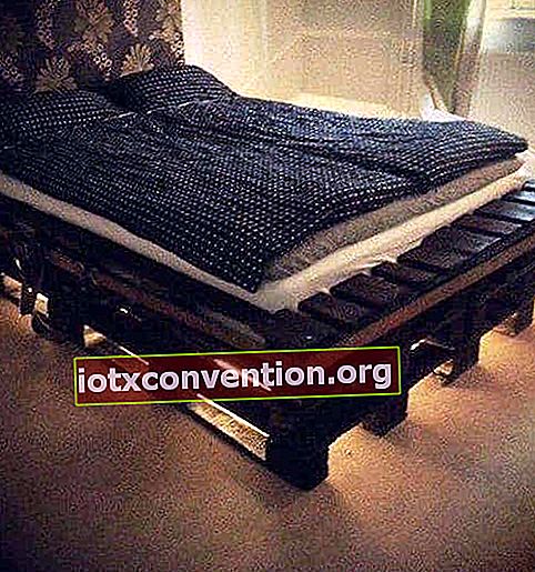 Bett mit Boxspring aus recycelter Holzpalette mit Licht darunter