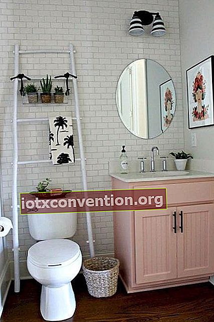 Sebuah tangga putih diletakkan di belakang toilet sebagai tempat penyimpanan di kamar mandi