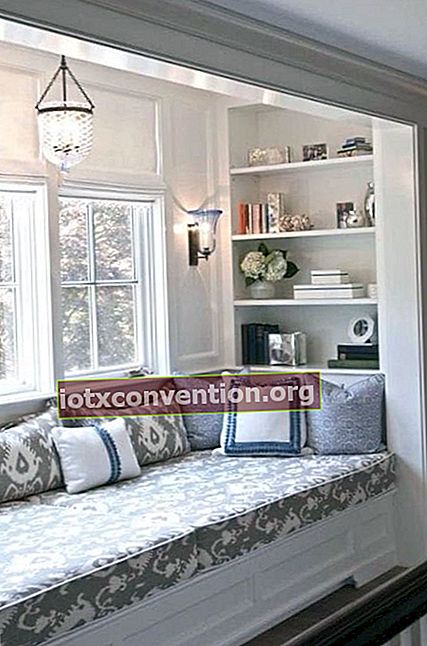 una panca è posta sotto una finestra con una mensola per creare una zona relax