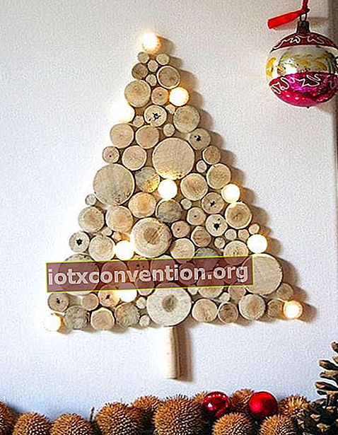 Un albero di Natale realizzato con tronchi di legno e ghirlande luminose