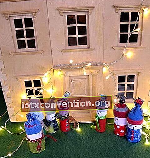 6 orang salji yang terbuat dari gulungan kertas tandas menyanyikan lagu-lagu Krismas di hadapan sebuah rumah