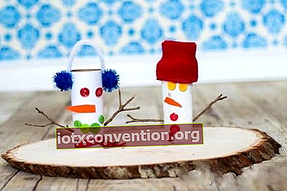 Snowman yang dibuat dari gulungan kertas tandas dilekatkan pada papan kayu hiasan