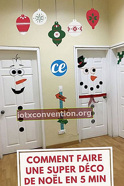ประตูสีขาวสองบานตกแต่งด้วยตุ๊กตาหิมะที่ทำจากกระดาษสำหรับคริสต์มาส