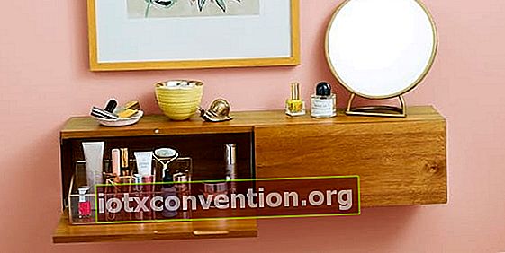Ein Holzregal mit einer Schublade, in der das Make-up in einem schönen Display aufbewahrt wird