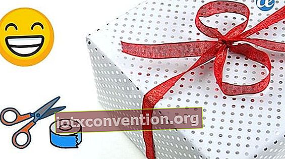 Ein Geschenk gut eingewickelt in Tupfenpapier und mit einem roten Band, auf einem weißen Hintergrund.