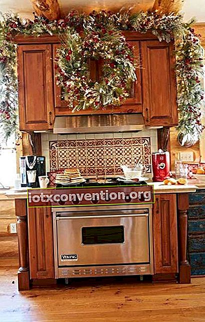 Grande ghirlanda verde e rossa appesa sopra il forno in cucina