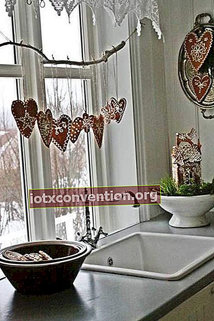 Karangan bunga kayu tergantung di jendela dapur dengan hati merah