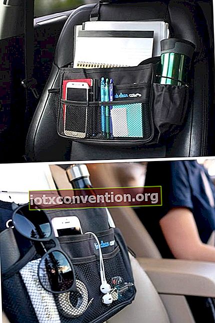 Un vano portaoggetti sul sedile anteriore dell'auto con telefono, bottiglia d'acqua e altri oggetti.