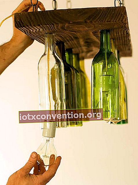 Mehrere Weinflaschen an einem hängenden Holzbrett befestigt