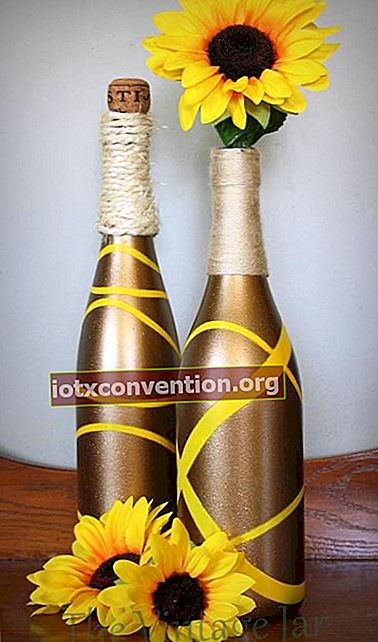 Bottiglia di vino decorata in oro e alcuni girasoli
