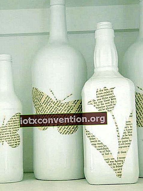 Bottiglie di vino bianco decorate con pezzi di libri ritagliati