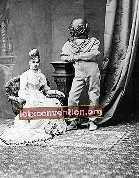 Sittande kvinna som bär en lång klänning bredvid en person med en undervattensdräkt