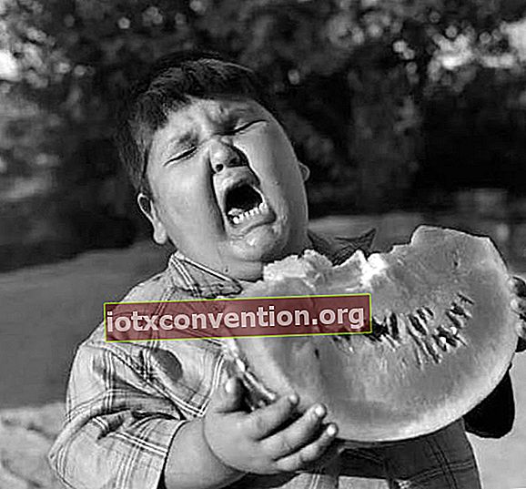 Junge, der Wassermelone mit krankem Kopf isst
