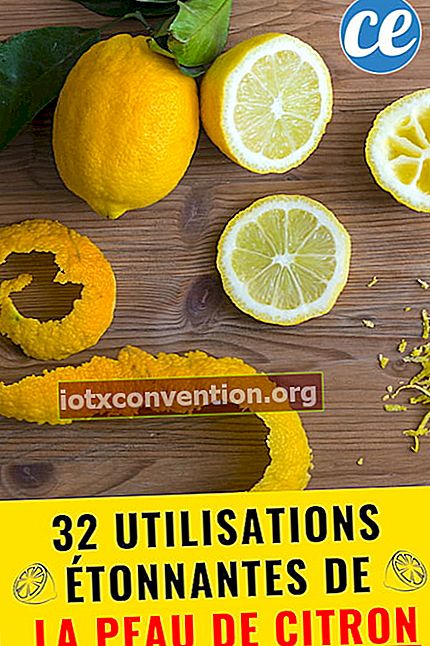Una scorza intera di limone e limone su una tavola di legno con un testo: 32 usi di scorza di limone