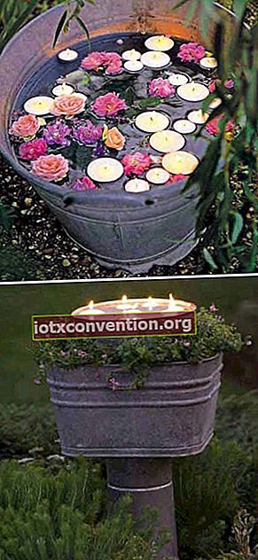 candele galleggianti in un secchio per decorare il giardino