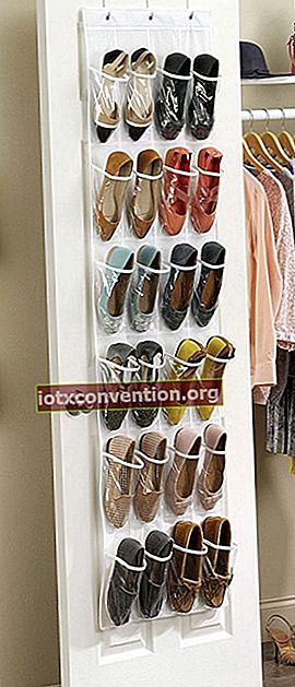 문 뒤에 매달린 플라스틱 신발 정리함에 보관 된 여성용 신발