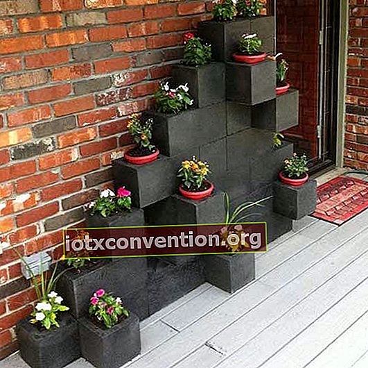 blocchi di cemento dipinti di nero e trasformati in vasi da fiori