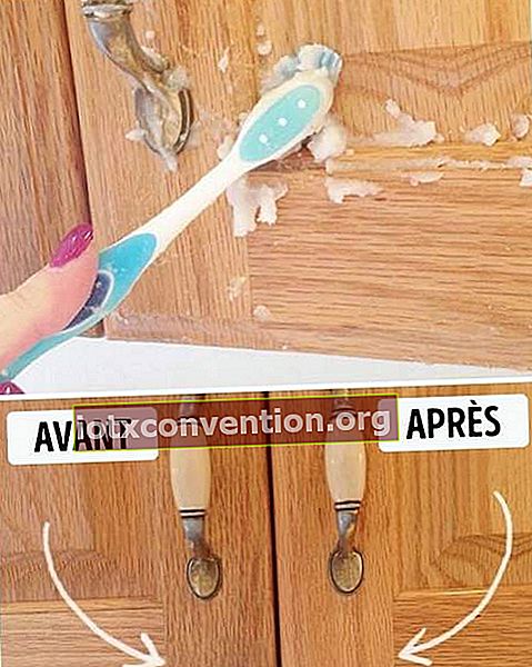 ทำความสะอาดประตูตู้ด้วยเบกกิ้งโซดาและน้ำมันเพื่อทำแป้ง ใช้แปรงสีฟันขัดประตู.