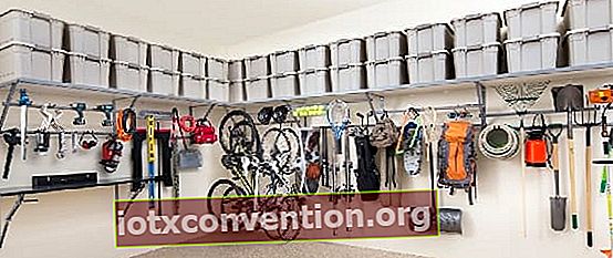 プラスチックの箱、道具、またはぶら下がっている自転車を備えた整頓されたガレージ