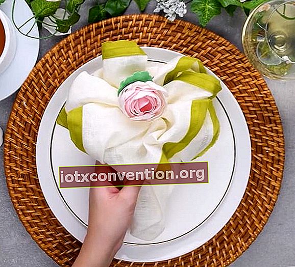Gefaltete Serviette in Form eines Blumenstraußes auf einem weißen Teller