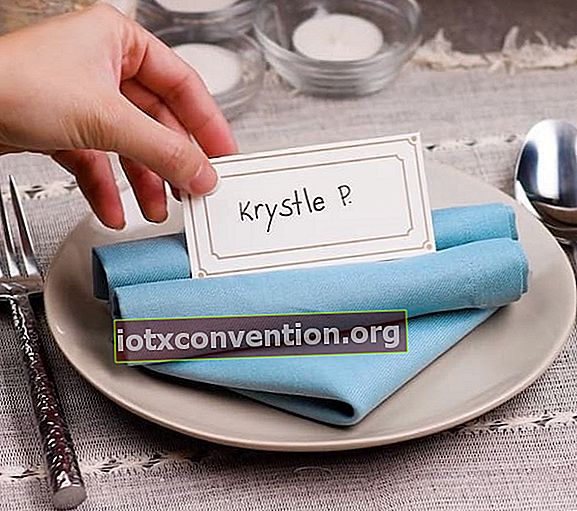 Blaue Serviette gefaltet in Tischkarten auf einem Teller