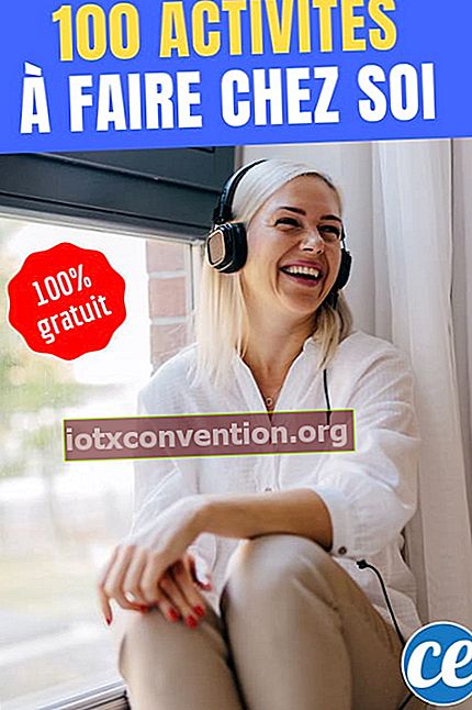 En kvinna lyssnar på musik med hörlurar nära fönstret