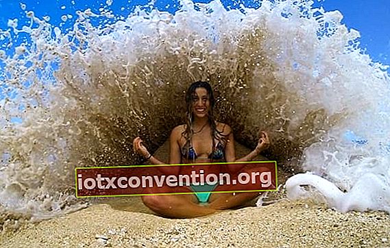 ผู้หญิงกำลังเล่นโยคะบนชายหาดริมน้ำ