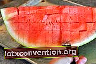 En kniv som skär köttet av en vattenmelon.