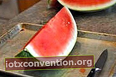 En vattenmelon i ett bakplåt, med en kniv.