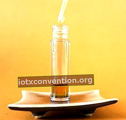 Eine Pipette, die ätherische Öle in eine Flasche gießt, um ein Anti-Falten-Serum herzustellen.