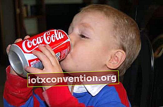 Bambino che beve una lattina di coca cola