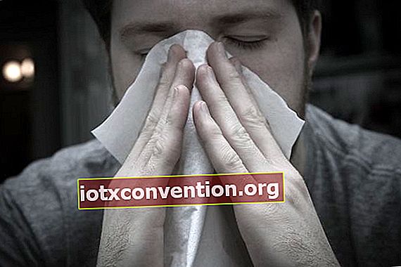 Mann putzt sich wegen Allergien die Nase mit einem Papiertaschentuch