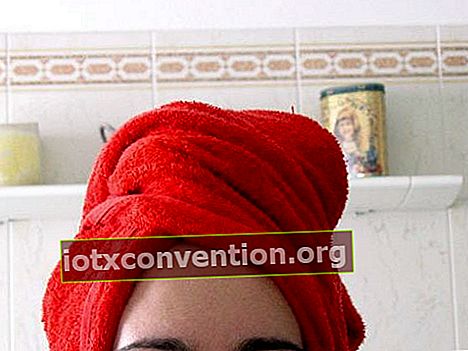 Rotes Handtuch auf dem Kopf nach dem Waschen der Haare