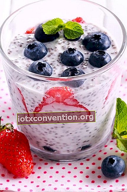 Eine Glasauflaufform mit Joghurt, Chiasamen und frischem Obst auf einer Tischdecke mit roten Tupfen.
