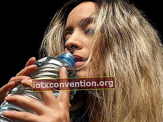 Una donna beve l'acqua da una bottiglia