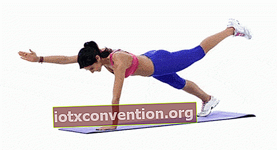 Eine Frau, die die diagonale Plankenübung macht, um ihre Bauchmuskeln zu stärken und einen flachen Bauch zu haben.