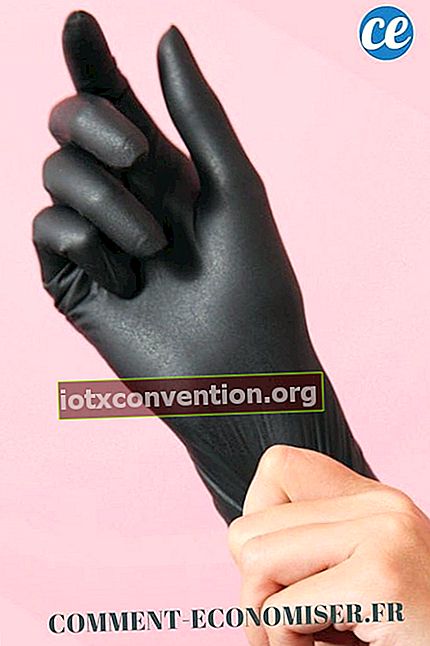 Sebuah tangan yang memakai sarung tangan karet hitam.